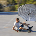 Skateboard land yacht, land sailor with beach umbrella sail in Western Australia